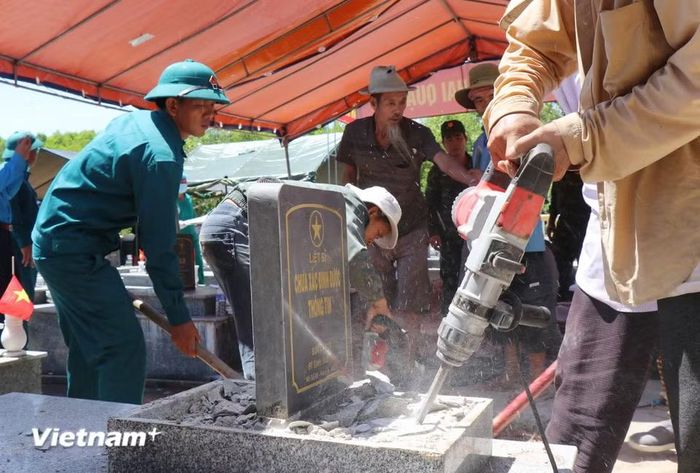 Việc lấy mẫu các phần mộ diễn ra khẩn trương, trách nhiệm trong điều kiện thời tiết khắc nghiệt, nắng nóng 38 độ C. (Ảnh: Phạm Cường/Vietnam+)
