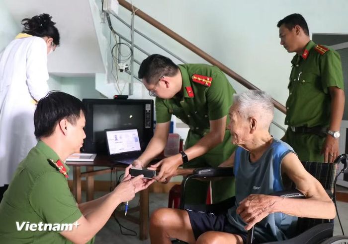 Công an xã Bình Sơn, Quảng Ngãi đến tận nhà thu nhập mẫu sinh phẩm cho người già, ốm đau. (Ảnh: Phạm Cường/Vietnam+)