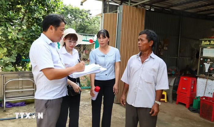 Cán bộ địa chính xã cùng lãnh đạo thôn Đức Thọ thống kê, ghi nhận hiện trạng sử dụng đất của các hộ dân phục vụ công tác cấp Giấy chứng nhận quyền sử dụng đất lần đầu. (Ảnh: Đậu Tất Thành/TTXVN)