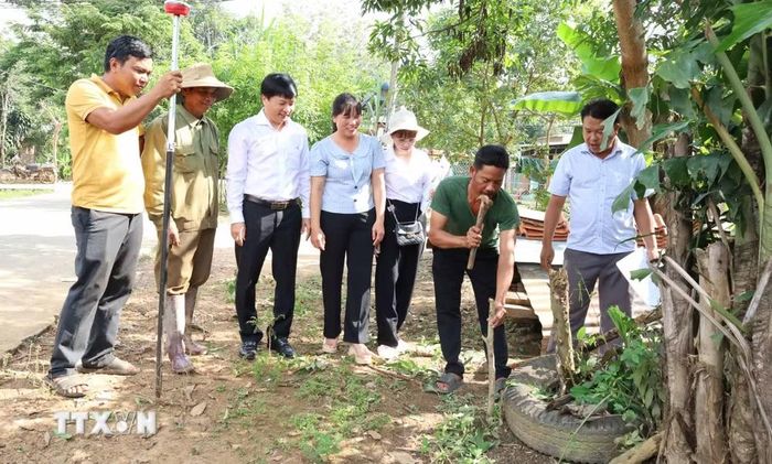 Công tác đo đạc, xác định ranh giới và cắm mốc thửa đất được thực hiện ngay tại hiện trường với sự chứng kiến của người dân và chính quyền địa phương. (Ảnh: Đậu Tất Thành/TTXVN)