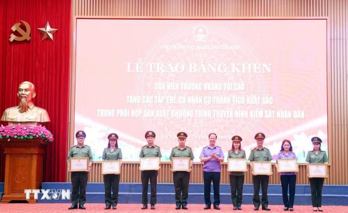 Phó Viện trưởng Viện Kiểm sát Nhân dân Tối cao Trần Hải Quân trao Bằng khen của Viện trưởng Viện Kiểm sát nhân dân tối cao cho các cá nhân có thành tích xuất sắc. (Ảnh: Phạm Kiên/TTXVN)