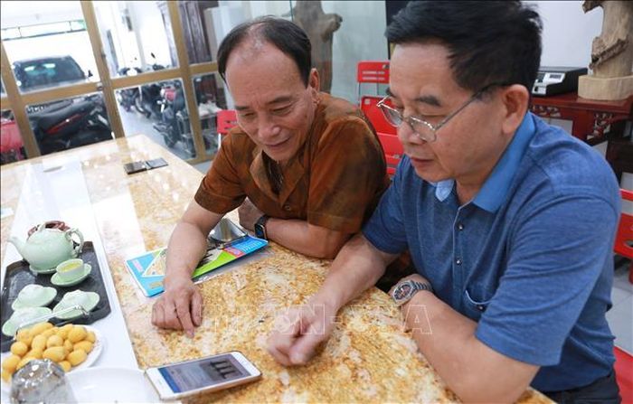 Ông Đào Quang Huynh (bên trái) cùng ông Đoàn Văn Tiến, Bí thư Chi bộ, Phó Tổng Giám đốc Công ty giám sát hoạt động của doanh nghiệp thông qua nền tảng số.