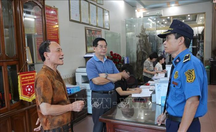 Ông Đào Quang Huynh (bên trái) trao đổi công việc với người lao động.