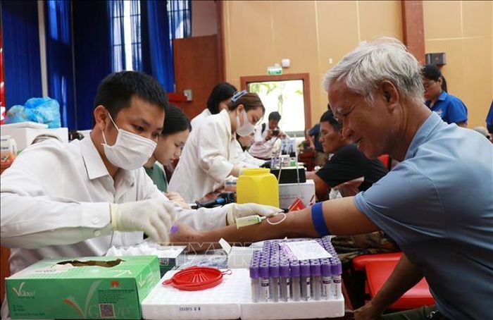 Cán bộ y tế phối hợp với các cơ quan chức năng lấy mẫu sinh phẩm ADN thân nhân liệt sĩ tại phường Nha Trang, tỉnh Khánh Hòa. Ảnh: Phan Sáu - TTXVN
