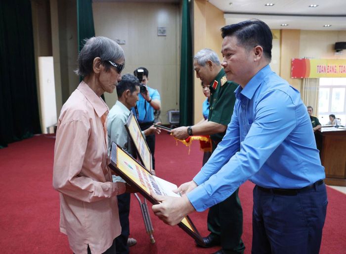 Ông Nguyễn Quang Huy, Phó Tổng Giám đốc công ty CP Dịch vụ Hàng không Thăng Long (TASECO) trao tượng trưng 30 triệu đồng giúp các gia đình sửa chữa nhà.