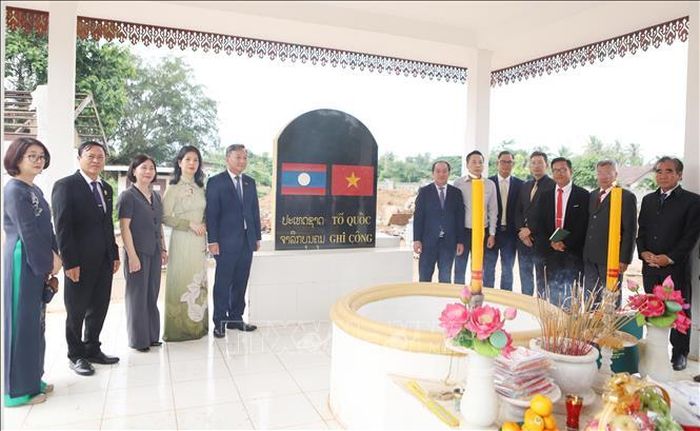 Các đại biểu hai nước Việt Nam - Lào chụp ảnh kỷ niệm sau khi đã dâng hương tưởng niệm các Anh hùng liệt sĩ tại Khu Di tích Liên quân Lào - Việt tại bản Keun. Ảnh: Xuân Tú/PV TTXVN tại Lào