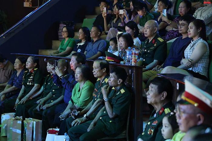 Các cựu chiến binh, thương binh và đông đảo khán giả theo dõi chương trình nghệ thuật.