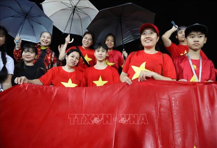 Mưa lớn không ngăn được tinh thần cổ vũ của các cổ động viên áo đỏ sao vàng. Ảnh: Đỗ Sinh/PV TTXVN tại Thái Lan