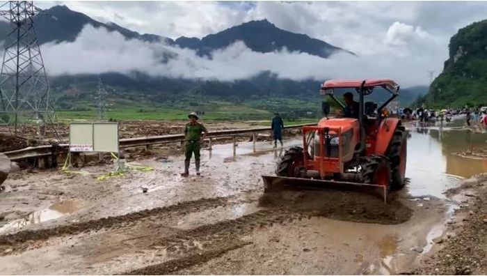 Lực lượng chức năng đã sử dụng máy xúc để khơi thông đoạn đường Quốc lộ 32. Ảnh: Đức Bình/Nông nghiệp và Môi trường