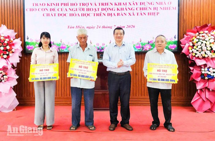 Bí thư Đảng ủy, Chủ tịch HĐND xã Tân Hiệp Đinh Xuân Phương trao bảng tượng trưng hỗ trợ kinh phí xây nhà mới cho 3 hộ gia đình.