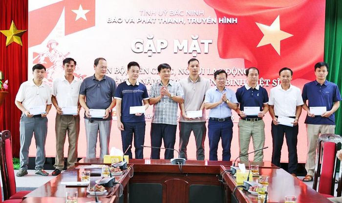  Các đồng chí Phó Giám đốc Báo và Phát thanh, Truyền hình Bắc Ninh: Nguyễn Giang Nam, Lê Thanh Hóa trao quà của cơ quan tới cán bộ, viên chức, người lao động để chuyển đến thân nhân là người có công. 