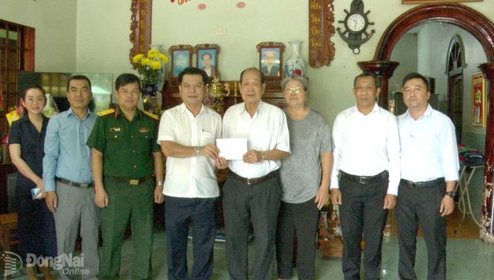Chủ tịch UBND phường Bình Lộc Đào Đại Giang cùng thành viên đoàn tặng quà thương binh Nguyễn Xuân Khảm. Ảnh: Minh Anh