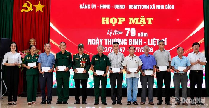 Lãnh đạo xã Nha Bích tặng quà các gia đình chính sách tại buổi họp mặt. Ảnh Tiến Công