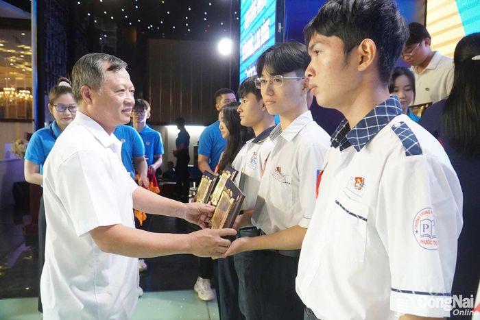 Phó Chủ tịch Ủy ban MTTQ Việt Nam thành phố Nguyễn Tấn Phú trao khen thưởng các em học sinh. Ảnh: N.Hòa
