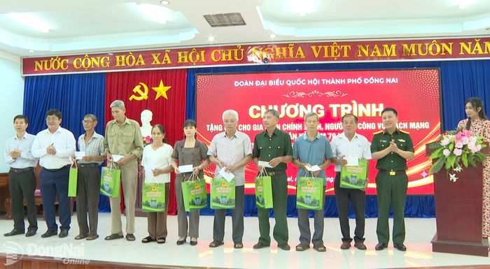 Thành ủy viên, Giám đốc Sở Khoa học và Công nghệ Phạm Văn Trinh cùng đại diện các đơn vị tài trợ tặng quà cho gia đình chính sách và người có công ở xã Bù Đăng. Ảnh: Thanh Lâm
