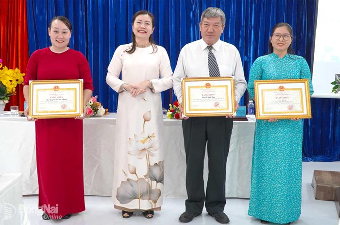Phó Giám đốc Sở Tư pháp thành phố Đồng Nai Lý Hậu Hồng Lê tặng bằng khen của Bộ trưởng Bộ Tư pháp cho các tập thể, cá nhân có thành tích xuất sắc trong phong trào thi đua theo chuyên đề. Ảnh: An Nhơn