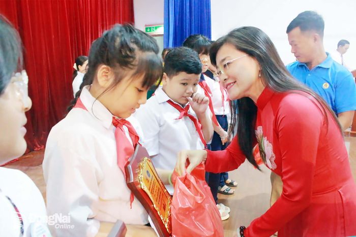 Phó Chủ tịch Liên đoàn Lao động thành phố Bùi Thị Bích Thủy trao khen thưởng cho con công nhân Công ty TNHH Pou Chen Việt Nam. Ảnh: Thảo My
