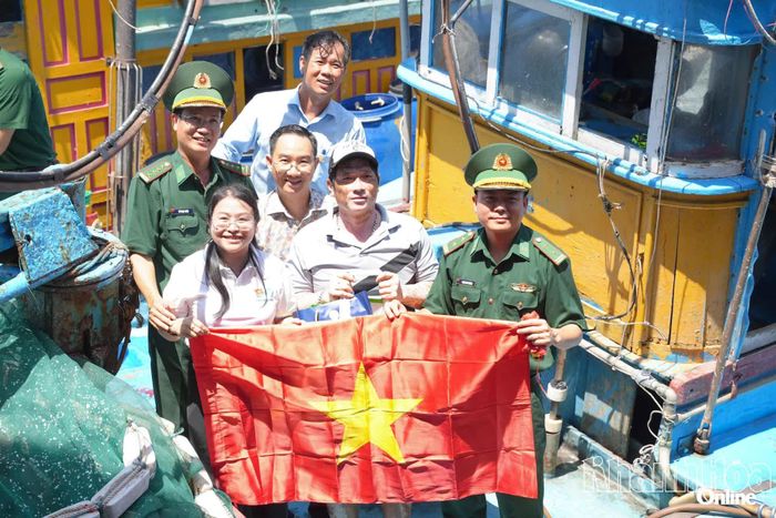 Các đại biểu trao cờ Tổ quốc cho các tàu cá neo đậu tại cảng Đá Bạc.