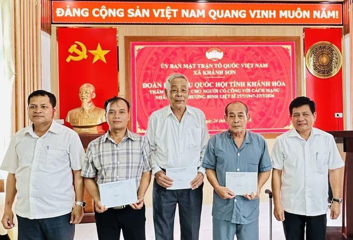 Lãnh đạo xã Khánh Sơn trao quà cho người có công với cách mạng.