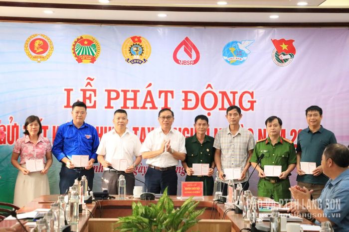 Lãnh đạo UBND xã Đình Lập trao sổ tiết kiệm cho các đại biểu tham gia gửi tiết kiệm