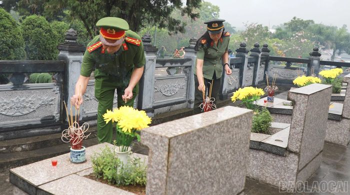 Đại tá Nguyễn Tiến Đỗ và đoàn công tác thắp hương tại các phần mộ liệt sĩ.