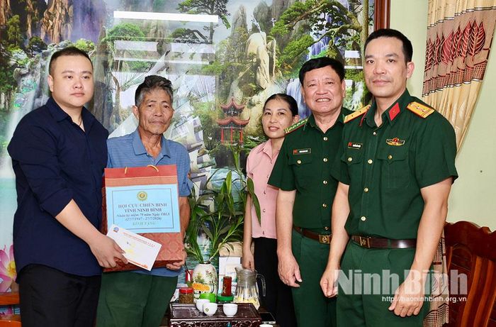 Lãnh đạo Hội CCB tỉnh cùng lãnh đạo Viettel chi nhánh Ninh Bình,Doanh nghiệp tư nhân Hoàng Sơn tặng quà cho CCB Tống Duy Đích, ở xã Khánh Nhạc. Ảnh: Ngọc Ánh