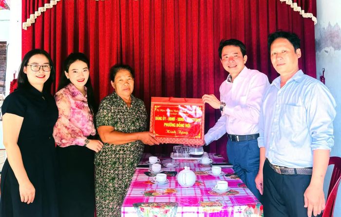 Đại diện lãnh đạo UBND phường Đồng Hới và các thành viên đoàn công tác trao quà bà Trần Thị Tuyến, thân nhân liệt sĩ, ở tổ dân phố Phú Hải - Ảnh: P.V