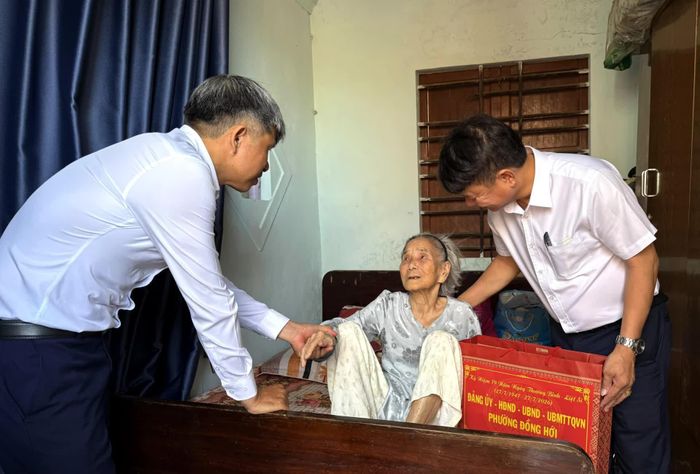 Đại diện lãnh đạo Ủy ban MTTQ Việt Nam phường Đồng Hới và thành viên đoàn công tác trao tặng quà bà Nguyễn Thị Hương, thân nhân liệt sĩ, ở tổ dân phố Bảo Ninh 3 - Ảnh: P.V
