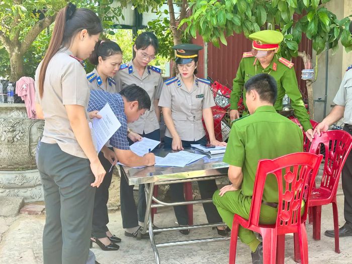 Đại diện các cơ quan chức năng lập biên bản, xác nhận kết quả cưỡng chế - Ảnh: Thùy Trang