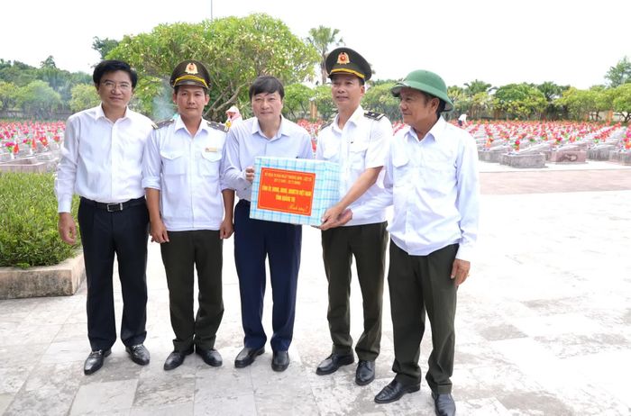 Đồng chí Lê Hồng Vinh, Chủ tịch UBND tỉnh và đồng chí Trương An Ninh, Trưởng ban Tuyên giáo và Dân vận Tỉnh ủy tặng quà các nhân viên làm nhiệm vụ quản lý, chăm sóc các phần mộ liệt sĩ tại Nghĩa trang liệt sĩ Ba Dốc - Ảnh: T.Đ