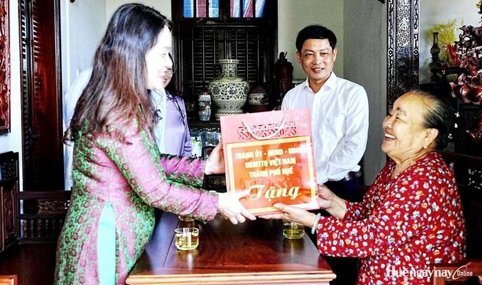 Đồng chí Hồ Thị Thu Hằng trao quà cho bà Hồ Thị Thỏn. Ảnh: Minh Văn