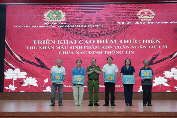 Đại tá Trần Minh Trúc, Phó giám đốc Công an tỉnh Khánh Hòa trao quà cho thân nhân liệt sĩ.
