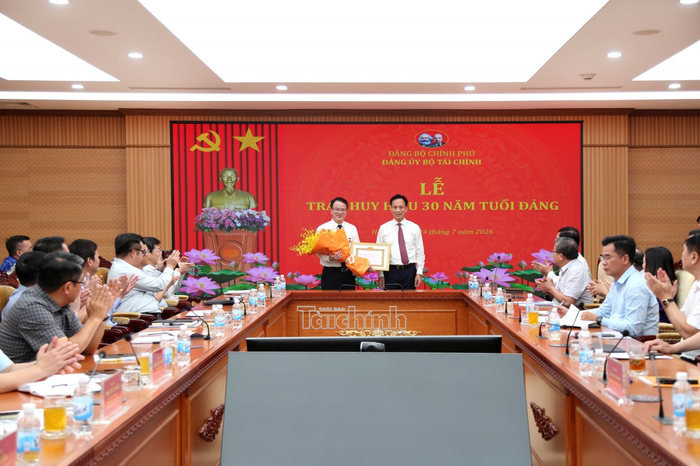 Phó Bí thư Đảng ủy Chính phủ Lại Xuân Lâm trao Huy hiệu 30 năm tuổi Đảng và tặng hoa chúc mừng Thứ trưởng Bộ Tài chính Trần Quốc Phương. Ảnh: Đức Minh