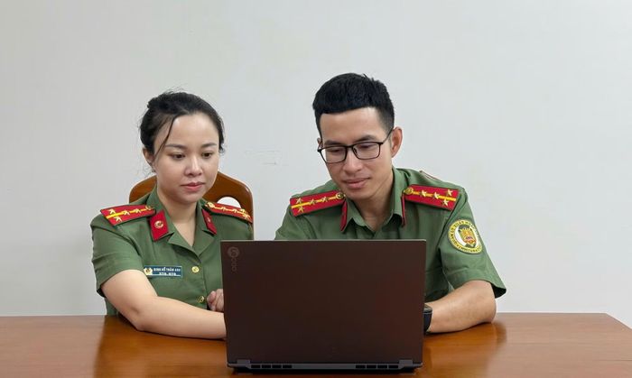 Đại úy Đinh Hồ Trâm Anh - thành viên nhóm tác giả sáng kiến hệ thống FRF trao đổi phương pháp vận hành hệ thống với đồng đội ở Phòng QLXNC Công an tỉnh Khánh Hòa.
