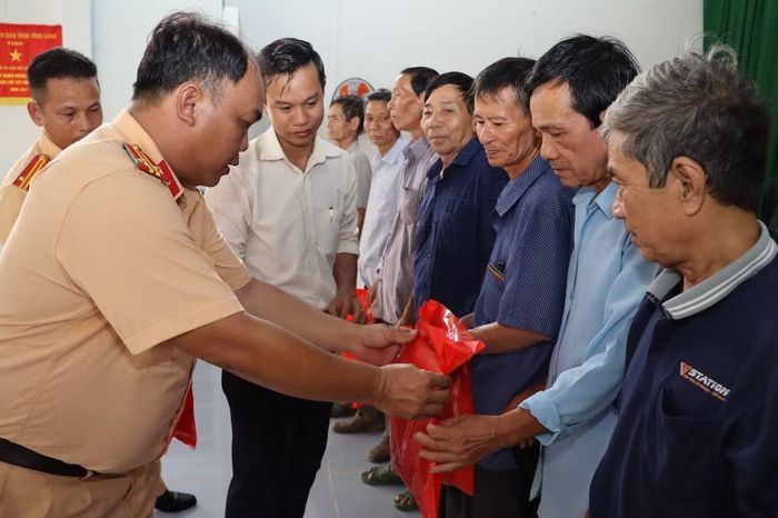 Trung tá Đoàn Thanh Danh, Phó Thủy đội, Thủy đoàn II tặng quà cho người dân và cựu chiến binh xã Quới Thiện.