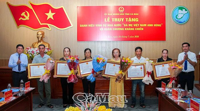 Phó Chủ tịch UBND tỉnh Lê Văn Sử và Phó Chủ tịch Ủy ban MTTQ Việt Nam tỉnh Cà Mau Bùi Minh Hải trao Huân chương Kháng chiến và tặng hoa thân nhân các liệt sĩ được Chủ tịch nước truy tặng.