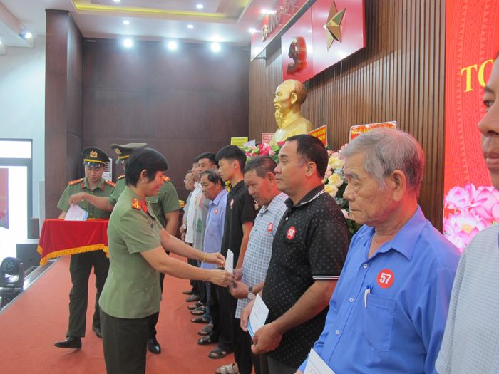 Thượng tá Cao Thị Hồng Tươi, Phó trưởng Phòng Tham mưu CATP trao quà của Ban Chỉ đạo 138 Thành phố cho các hộ gia đình khó khăn ở xã Hóc Môn.