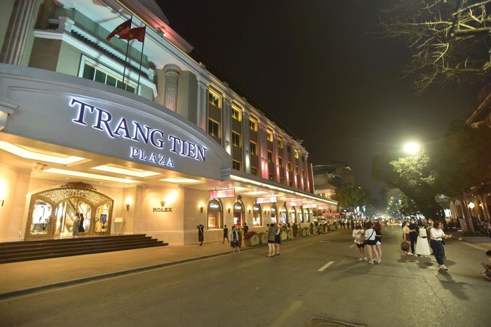 Hoạt động thương mại và giải trí vận hành trong khung thời gian từ 22h hôm trước đến 2h hôm sau tại khu vực được phép. Theo điểm b, c, khoản 1 Điều 10 Nghị quyết 34/2026/NQ-HĐND, việc kéo dài thời gian hoạt động sau 22h hôm trước đến 2h hoặc 6h hôm sau chỉ áp dụng có chọn lọc tại các khu vực tách biệt, đáp ứng tiêu chuẩn khắt khe về an ninh, cách âm và quản lý đô thị. (Ảnh: Trung tâm thương mại Hoàn Kiếm rực sáng về đêm)