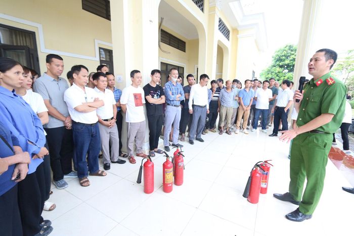 Đại úy Nguyễn Văn Lưu, báo cáo viên của Đội Chữa cháy và cứu nạn, cứu hộ khu vực số 30 hướng dẫn các chủ hộ kinh doanh, cơ sở kinh doanh sử dụng bình chữa cháy. Ảnh: Công Phương