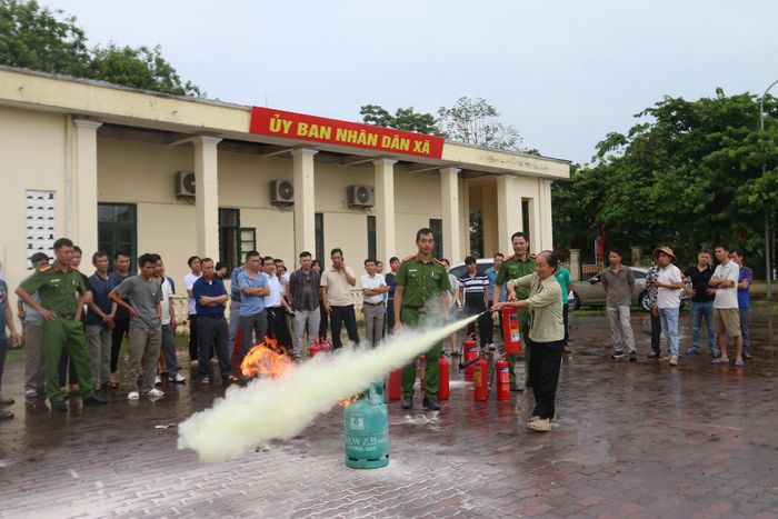 Đại diện các cơ sở kinh doanh trên địa bàn xã Tây Phương lên thực hành dùng bình chữa cháy dập lửa. Ảnh: Công Phương