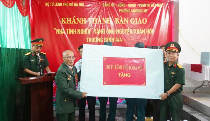 Lãnh đạo Bộ Tư lệnh Thủ đô Hà Nội trao vật dụng sinh hoạt tặng thương binh Nguyễn Xuân Hòe. Ảnh: Lan Oanh