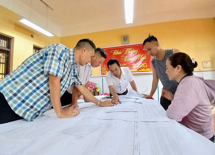 Cán bộ và người dân thôn Nhị Xuân so sánh thông tin, tìm thửa đất trên bản đồ. Ảnh: Hoàng Quyết