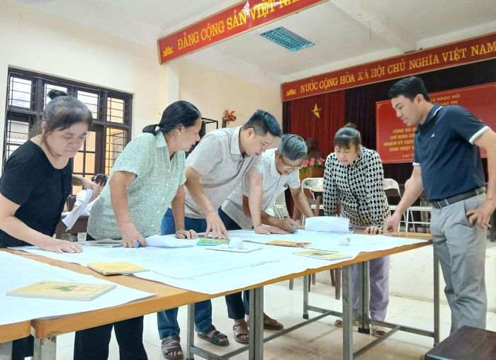 Cán bộ và người dân thôn Lạc Thị đối chiếu hồ sơ, định vị thửa đất trên bản đồ. Ảnh: Hoàng Quyết
