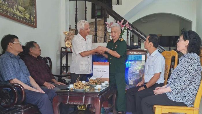 Chủ tịch Hội Người cao tuổi thành phố Hà Nội Nguyễn Thế Toàn thăm hỏi thương binh Nguyễn Văn Dư. Ảnh: PV