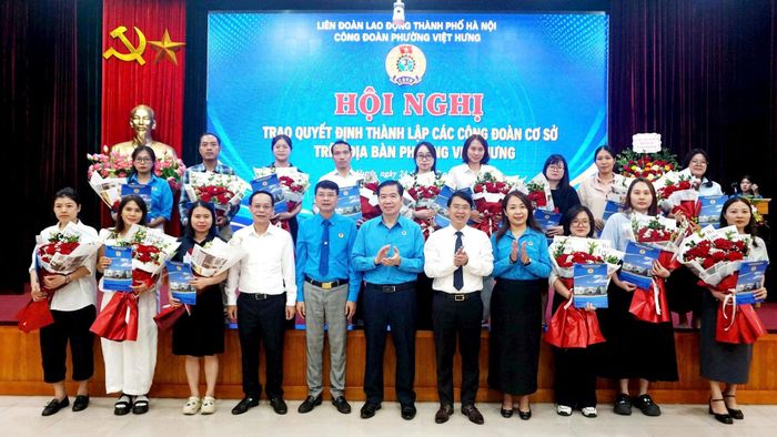 Lãnh đạo Liên đoàn Lao động thành phố Hà Nội và phường Việt Hưng trao Quyết định, tặng hoa tới các công đoàn cơ sở thành lập mới. Ảnh: B.Duy