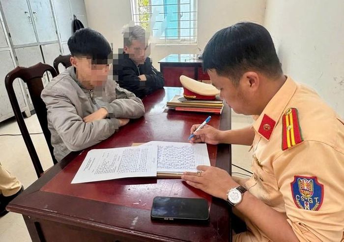 Cán bộ Đội Cảnh sát giao thông đường bộ số 5 lập biên bản đối với thanh niên vi phạm. Ảnh: CALĐ.