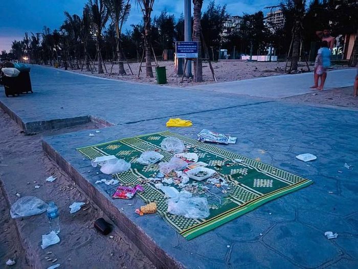 Rác thải, chai nhựa và túi ni lông bị bỏ lại trên tấm chiếu sau cuộc ăn uống tại bãi biển Cửa Lò (Nghệ An). Ảnh: Thế Sơn.