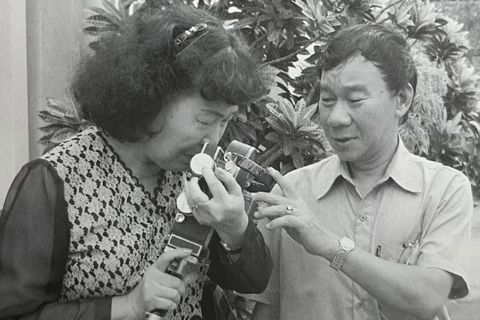 Bà Hiên xúc động khi nhận lại chiếc máy ảnh của chồng. Ảnh chụp từ sách.