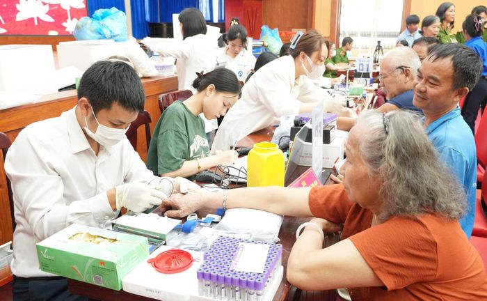 Thu nhận mẫu sinh phẩm ADN của thân nhân liệt sĩ chưa xác định thông tin. Ảnh: TTXVN