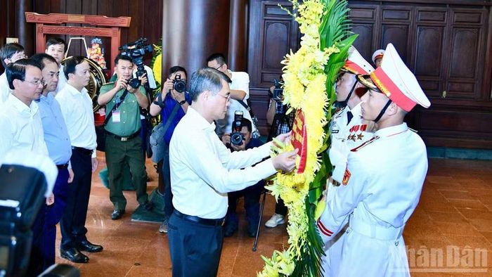 Thủ tướng Lê Minh Hưng chỉnh hoa trước khi thực hiện nghi lễ dâng hương, dâng hoa tưởng nhớ các Anh hùng liệt sĩ chiến trường Điện Biên Phủ. (Ảnh: THANH GIANG)